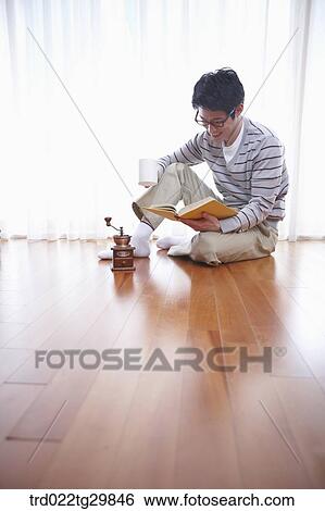 Stock Photograph - man reading book drinkin coffee. Fotosearch