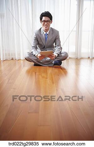 Stock Photography - man seeing the tablet pc on the floor. Fotosearch