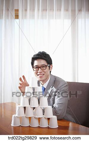 man sitting behind the stack of paper cups View Large Photo Image Stock Photo - man sitting behind the stack of paper cups. Fotosearch