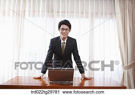 Stock Image - man standing in front of the desk. Fotosearch