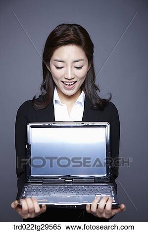 Stock Photography - woman holding laptop. Fotosearch