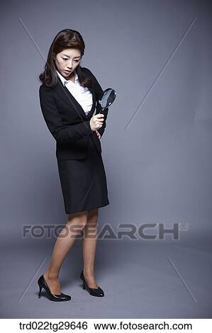 Stock Photograph - woman holding magnifying glass. Fotosearch