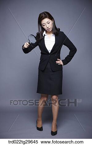 Stock Photography - woman holding magnifying glass. Fotosearch