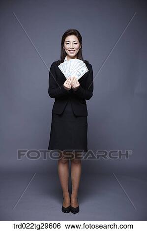 Stock Photograph - woman holding money bills. Fotosearch