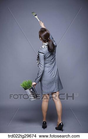 Picture - woman raise a brush to the air. Fotosearch