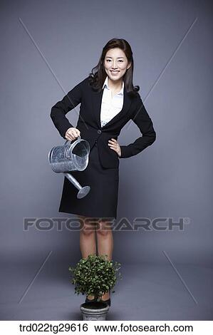 Stock Photograph - woman watering plant. Fotosearch