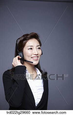 Stock Image - woman wearing headset. Fotosearch