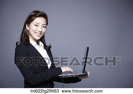 Stock Image - woman working by using laptop. Fotosearch