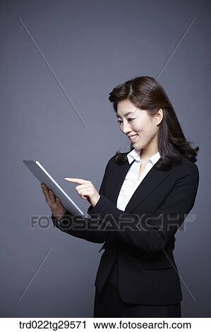Stock Image - woman working by using tablet pc. Fotosearch