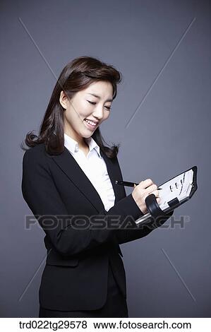 Stock Photo - woman writing something on the notebook. Fotosearch
