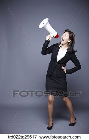 Stock Photo - woman yelling to loud speaker. Fotosearch