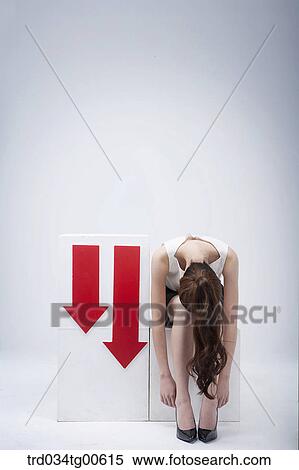 A bending woman beside going down arrows View Large Photo Image Stock Photography - A bending woman beside going down arrows. Fotosearch