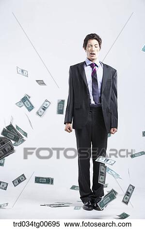 Stock Photography - A man hard to stand and flying money. Fotosearch