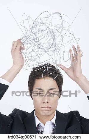 A stressful man holding up twisted wire ball View Large Photo Image Stock Image - A stressful man holding up twisted wire ball. Fotosearch