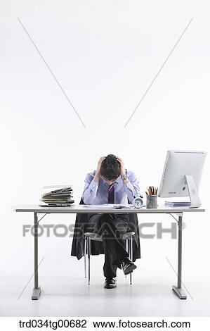 A stressful man while sitting on his desk View Large Photo Image Stock Image - A stressful man while sitting on his desk. Fotosearch