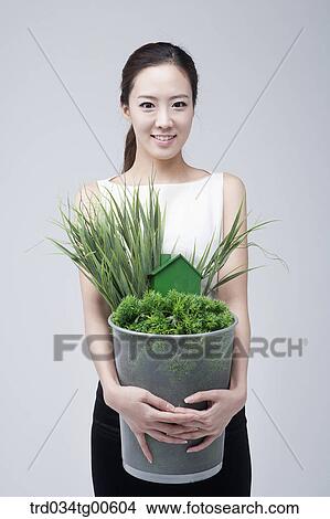A woman holding the basket of grass and green house View Large Photo Image Picture - A woman holding the basket of grass and green house. Fotosearch