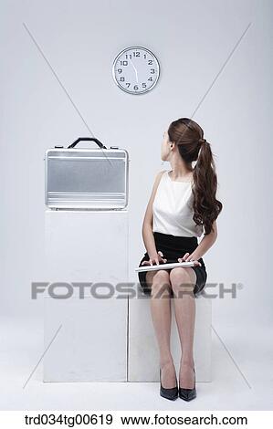 A woman looking back at clock while typing keyboard View Large Photo Image Stock Photo - A woman looking back at clock while typing keyboard. Fotosearch