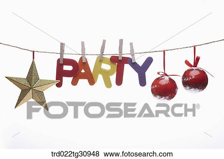 Stock Photo - The colorful party word, red Christmas balls, and gold star hung upon the string. Fotosearch