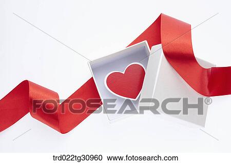 Stock Image - The red heart in the white box with red decoration tie. Fotosearch