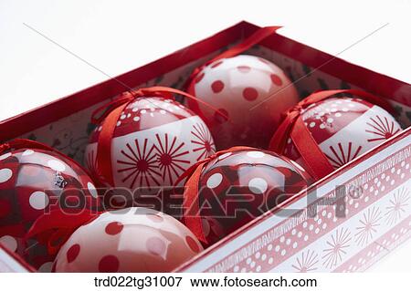 Stock Photo - The red ribboned Christmas ball decorations in the box. Fotosearch
