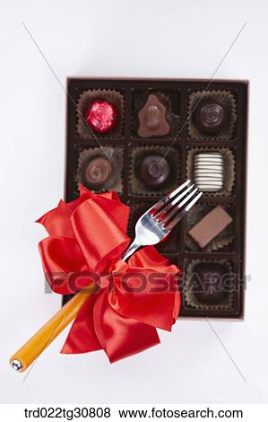 A box of chocolate and a folk with red ribbon View Large Photo Image Stock Photo - A box of chocolate and a folk with red ribbon. Fotosearch