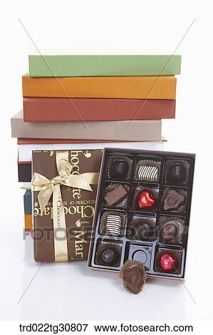 Stock Photo - A box of chocolate and stacks of books. Fotosearch