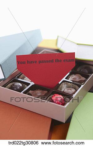 Stock Photograph - A box of chocolate in the middle of books with message. Fotosearch