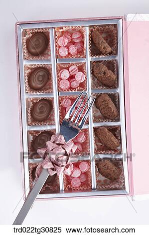 A box of sweets and a folk with ribbon View Large Photo Image Stock Photography - A box of sweets and a folk with ribbon. Fotosearch