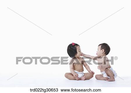Stock Image - Baby boy and girl in nappy. Fotosearch