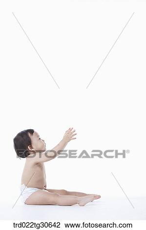 Stock Image - Baby boy in nappy standing. Fotosearch