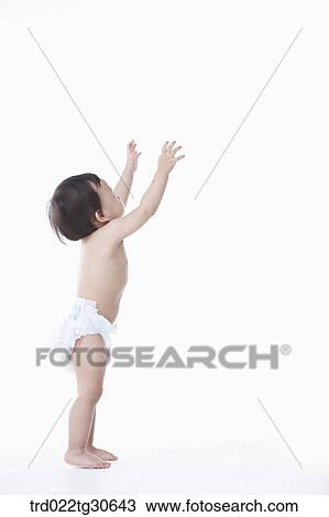 Stock Image - Baby boy in nappy standing. Fotosearch