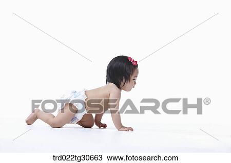 Stock Image - Baby girl in nappy crawling. Fotosearch