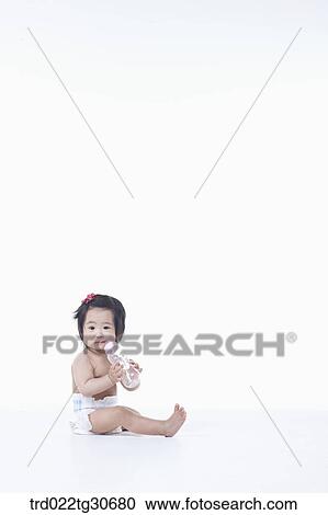 Baby girl in nappy with a baby bottle View Large Photo Image Stock Image - Baby girl in nappy with a baby bottle. Fotosearch