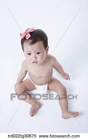 Stock Photography - Baby girl in nappy with pink ribbon. Fotosearch