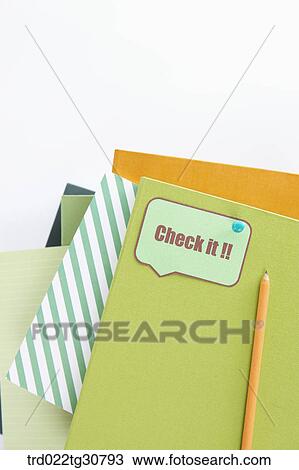 Stock Image - Books and Check it!! message with orange pencil. Fotosearch