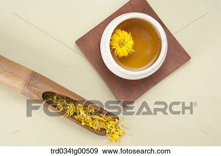 Stock Photo - Cup of dandelion tea and its dried flowers. Fotosearch