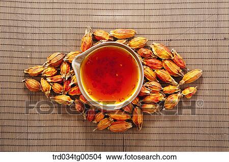 Picture - Cup of gardenia tea and its seeds. Fotosearch