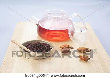Stock Image - Cups of Omija tea and its dried fruits. Fotosearch