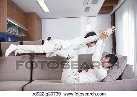 Father and son playing on the sofa View Large Photo Image Stock Photo - Father and son playing on the sofa. Fotosearch