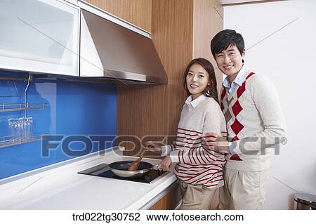 Happy couple cooking together in the kitchen View Large Photo Image Stock Image - Happy couple cooking together in the kitchen. Fotosearch
