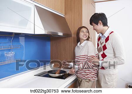 Happy couple cooking together in the kitchen View Large Photo Image Stock Image - Happy couple cooking together in the kitchen. Fotosearch