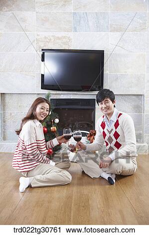 Happy couple with a wine in front of a fireplace View Large Photo Image Stock Image - Happy couple with a wine in front of a fireplace. Fotosearch