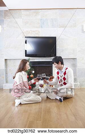 Happy couple with a wine in front of a fireplace View Large Photo Image Stock Image - Happy couple with a wine in front of a fireplace. Fotosearch