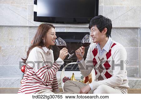 Happy couple with a wine in front of a fireplace View Large Photo Image Stock Photography - Happy couple with a wine in front of a fireplace. Fotosearch
