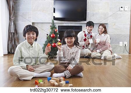 Stock Image - Happy family and a christmas tree. Fotosearch