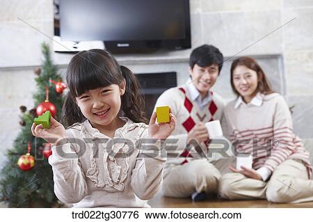 Stock Photograph - Happy family and a christmas tree. Fotosearch