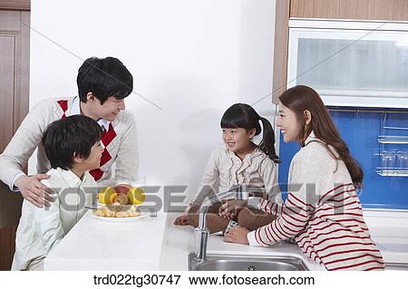 Stock Photo - Happy family on the kitchen top eating. Fotosearch