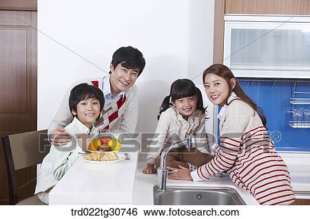 Happy family on the kitchen top eating View Large Photo Image Stock Photograph - Happy family on the kitchen top eating. Fotosearch