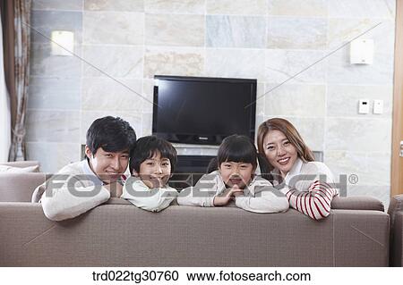 Stock Image - Happy family on the sofa and a televison. Fotosearch