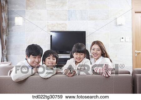 Stock Photo - Happy family on the sofa and a televison. Fotosearch